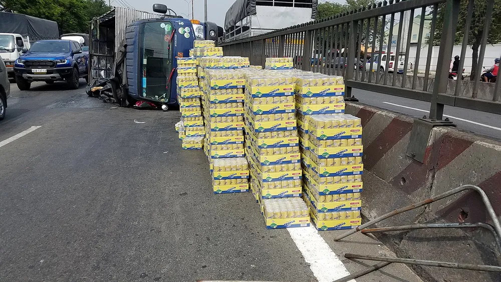  Xe tải lật giữa QL1, người dân cùng CSGT dọn hàng trăm thùng nước ngọt giúp tài xế ảnh 1