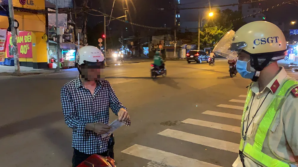 Anh N.T.D. không đeo khẩu trang bị lực lượng chặn lại kiểm tra xử phạt. Ảnh: CHÍ THẠCH 