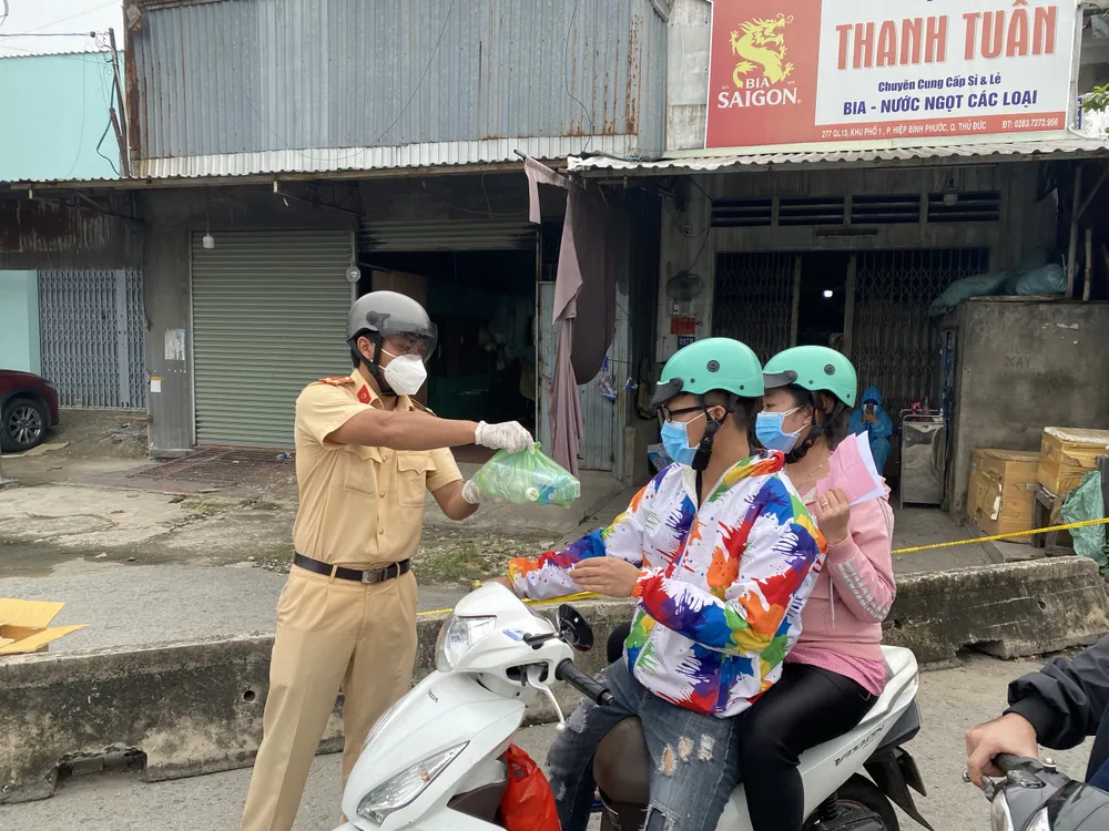 CSGT TPHCM hỗ trợ nước, sữa, khẩu trang... cho người dân trên đường về miền Tây  ảnh 2