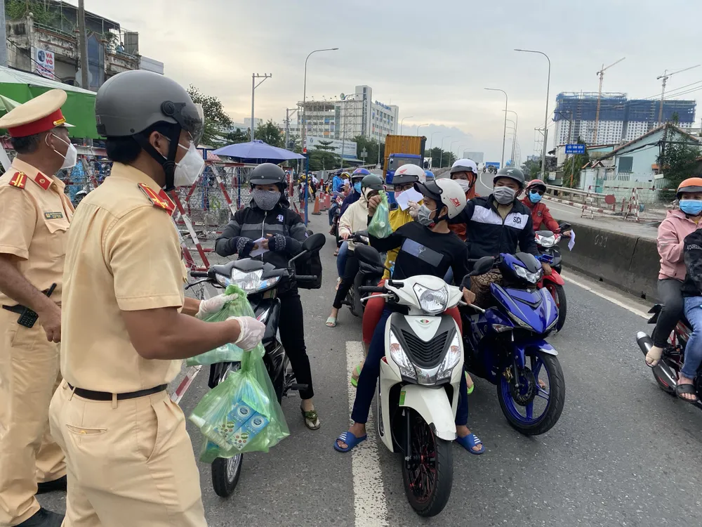 CSGT TPHCM hỗ trợ nước, sữa, khẩu trang... cho người dân trên đường về miền Tây  ảnh 1