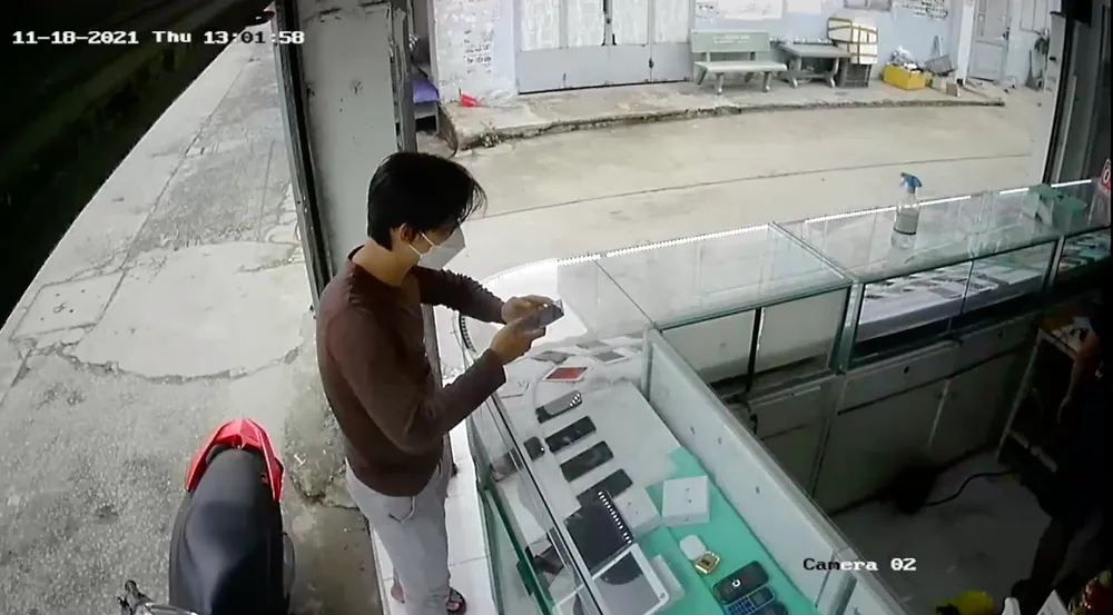 Chủ tiệm leo qua tủ kính truy đuổi thanh niên vờ mua rồi cướp điện thoại giữa ban ngày ảnh 1