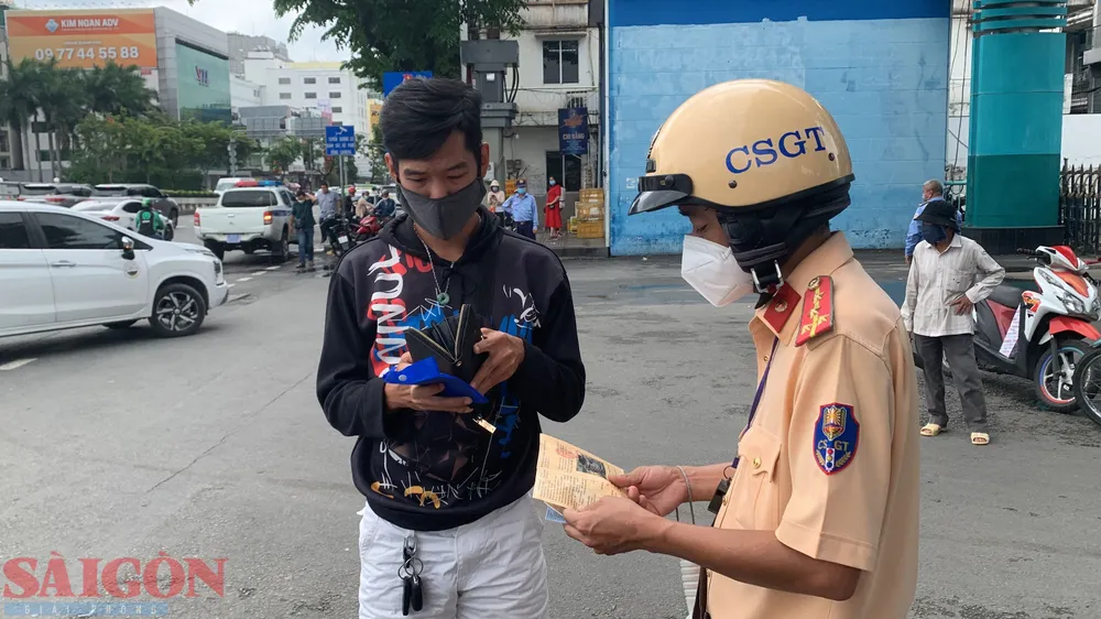 CSGT TPHCM kiểm tra với một tài xế. Ảnh: CHÍ THẠCH