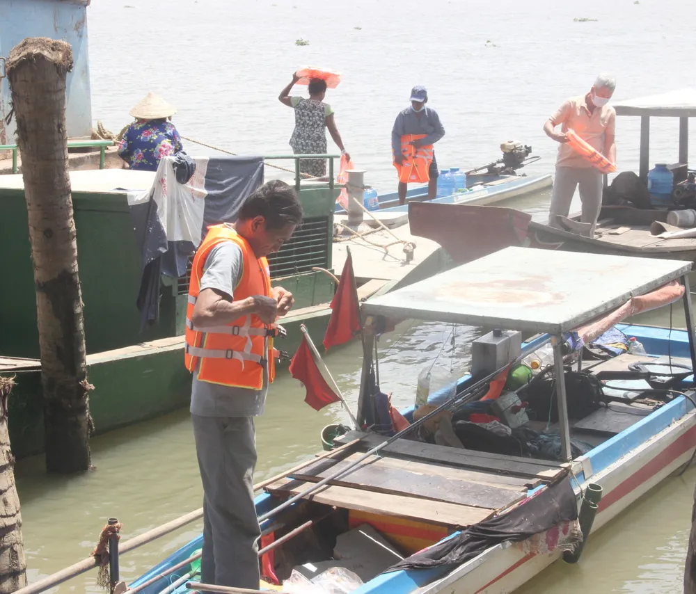 Người dân mặc áo phao để di chuyển trên sông