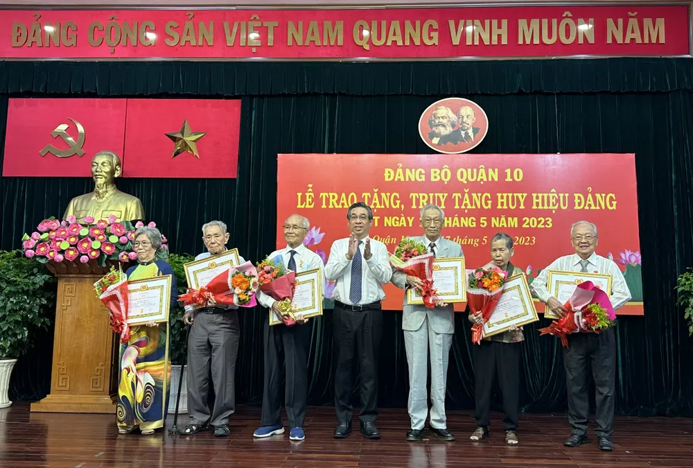 Trưởng Ban Tổ chức Thành ủy TPHCM Nguyễn Phước Lộc trao Huy hiệu Đảng cho đảng viên cao tuổi. Ảnh: CHÍ THẠCH