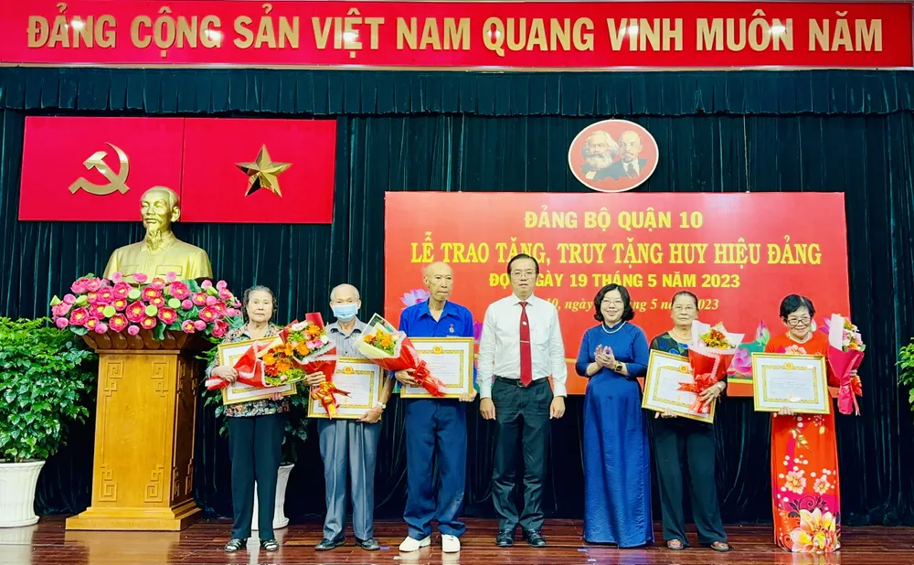 Bí thư Quận ủy quận 10 Lê Văn Minh cùng lãnh đạo quận 10 trao Huy hiệu Đảng cho đảng viên cao tuổi. Ảnh: CHÍ THẠCH