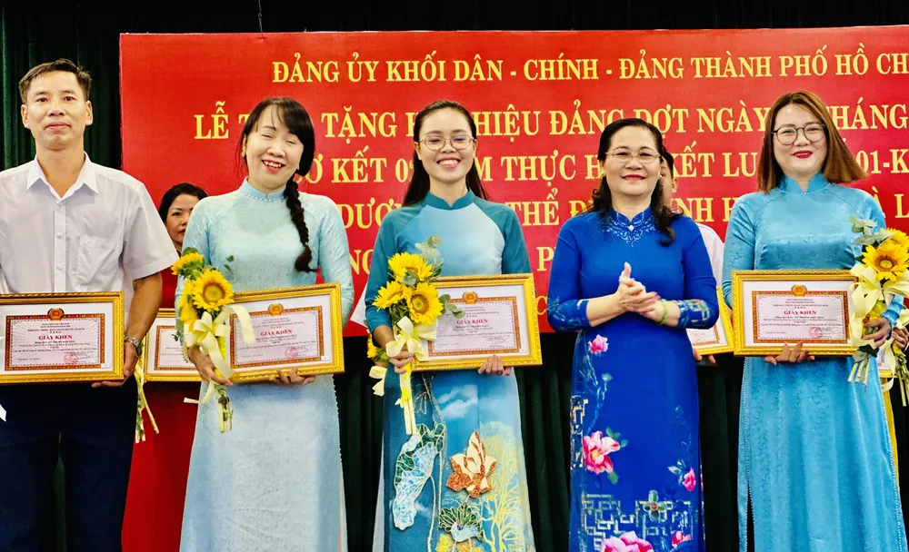 Chủ tịch HĐND TPHCM Nguyễn Thị Lệ trao bằng khen cá nhân, tập thể tham gia cuộc thi viết về công tác phòng, chống dịch Covid-19 trên địa bàn TPHCM. Ảnh: CHÍ THẠCH