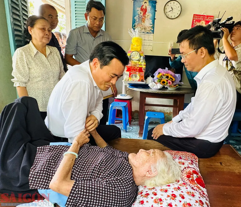 Phó Chủ tịch UBND TPHCM Bùi Xuân Cường ân cần thăm hỏi cụ Võ Thị Láng. Ảnh: CHÍ THẠCH