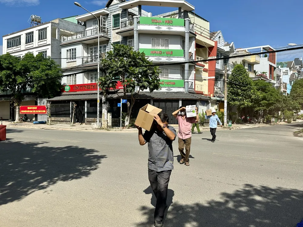 Người dân vận chuyển đồ dùng ra khu vực an toàn. Ảnh: CHÍ THẠCH