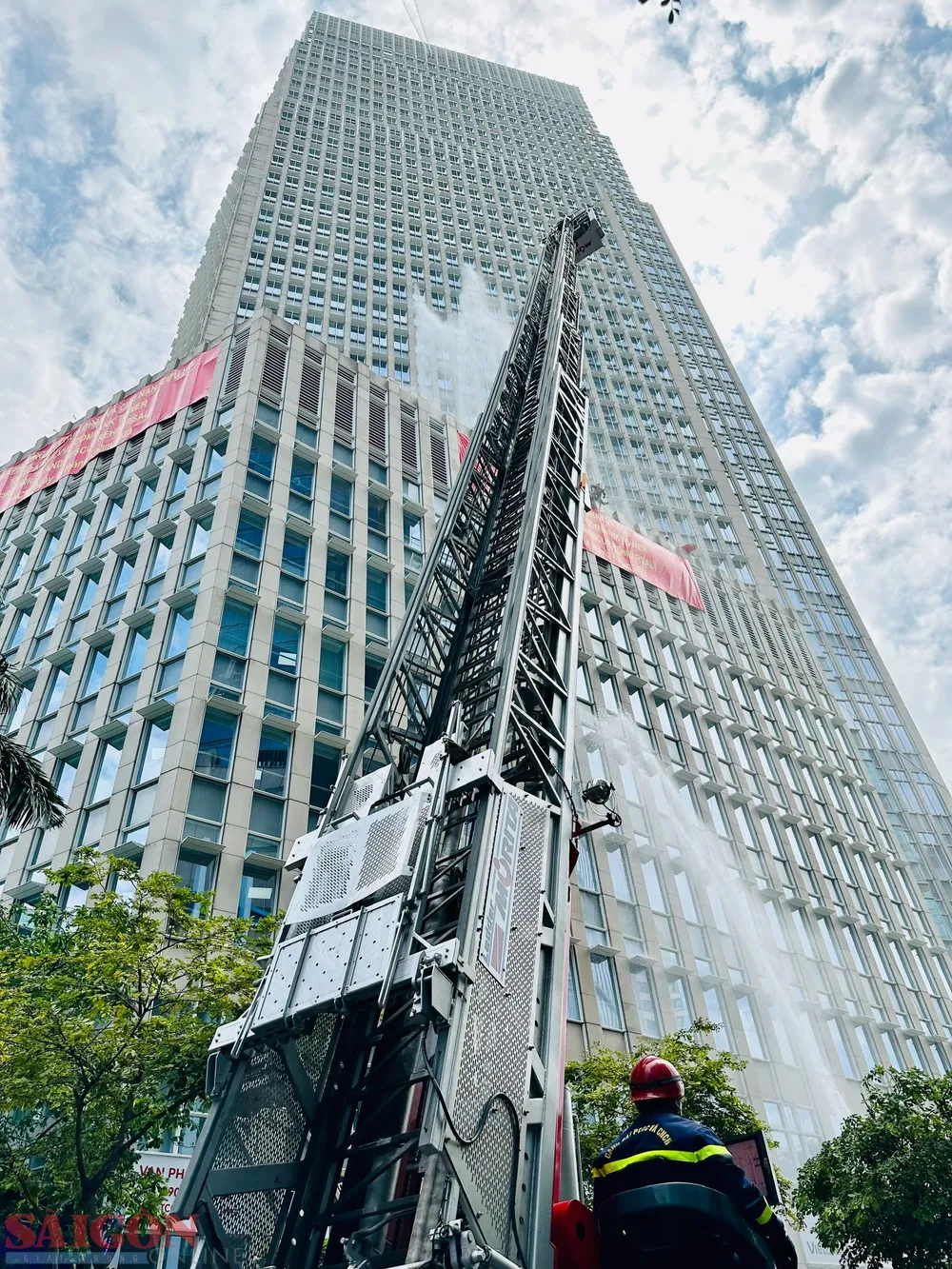Lực lượng chức năng dùng xe thang tiếp cận để cứu người và chữa cháy. Ảnh: CHÍ THẠCH
