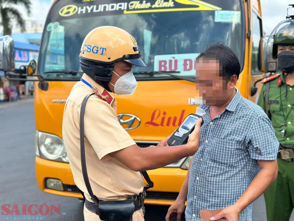 CSGT đo nồng độ cồn một tài xế tại Bến xe Miền Đông. Ảnh: CHÍ THẠCH