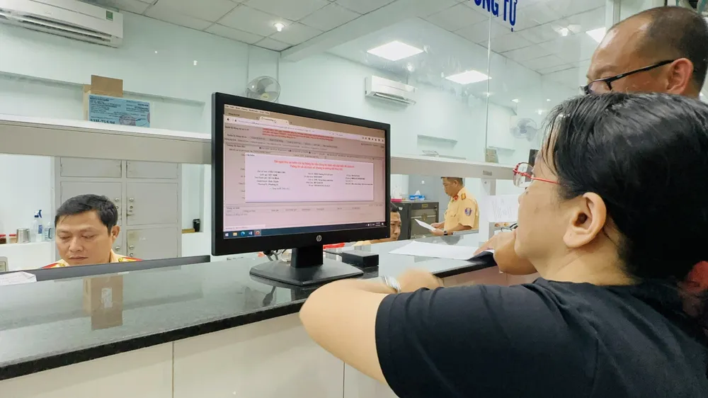 Người dân làm thủ tục tại Đội Đăng ký, quản lý phương tiện giao thông cơ giới đường bộ thuộc Phòng Cảnh sát giao thông đường bộ - đường sắt (PC08), Công an TPHCM