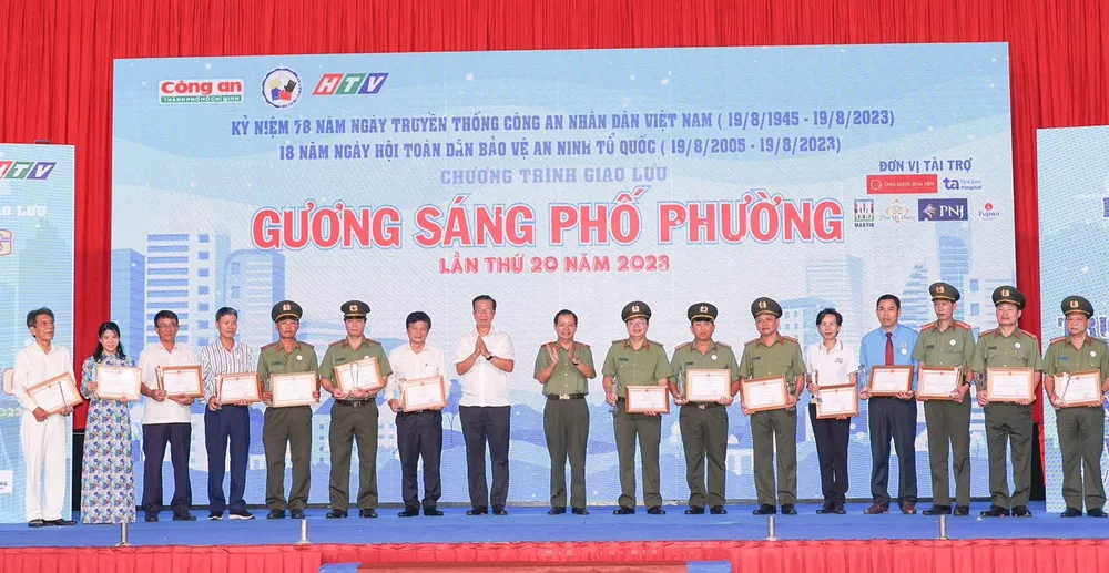 Thiếu tướng Trần Đức Tài, Phó Giám đốc Công an TPHCM; ông Phạm Đức Hải, Phó ban Tuyên giáo Thành ủy TPHCM trao giấy khen của Công an TPHCM và biểu trưng của chương trình tặng các cá nhân, tập thể có nhiều đóng góp cho chương trình trong suốt 20 năm qua