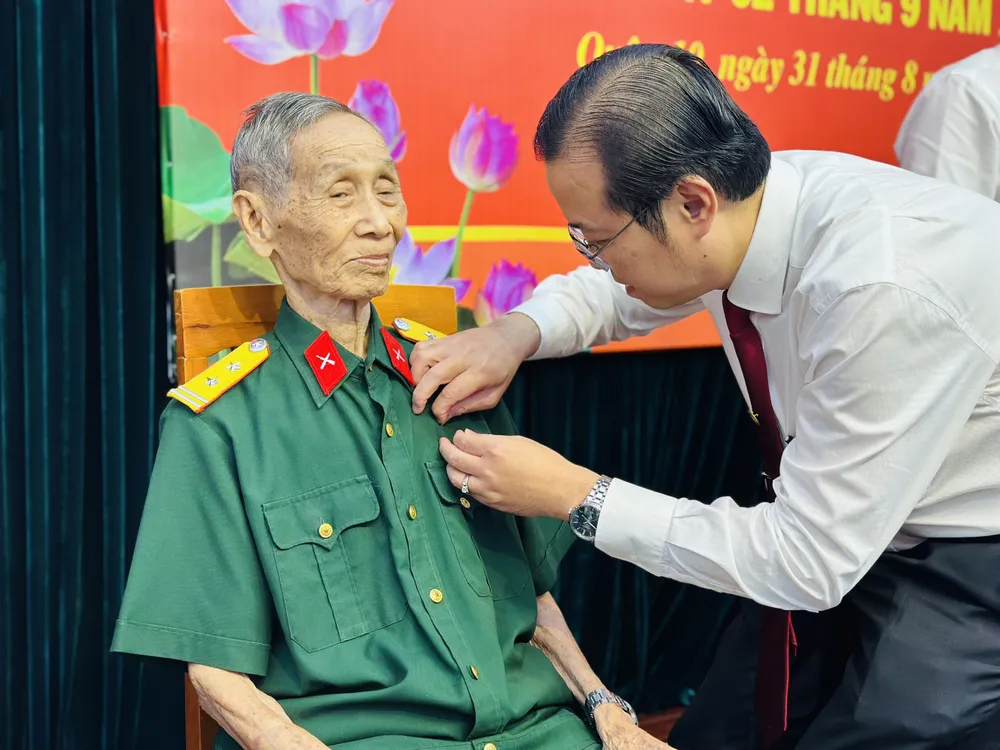 Bí thư Quận ủy quận 10 Lê Văn Minh trao Huy hiệu Đảng cho đảng viên cao tuổi Đảng. Ảnh: CHÍ THẠCH