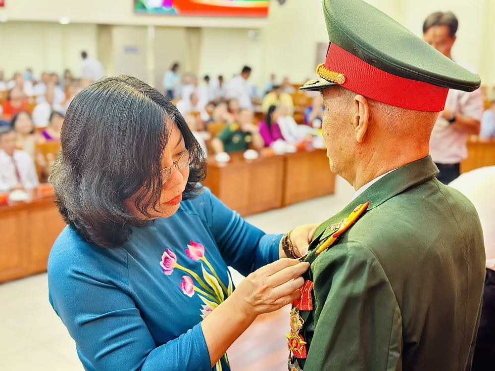 Chủ tịch UBND quận 10 Nguyễn Thị Thu Hường trao Huy hiệu Đảng cho đảng viên cao tuổi Đảng. Ảnh: CHÍ THẠCH