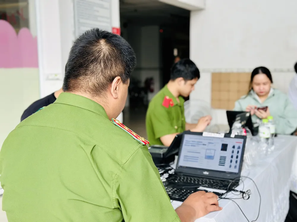 Công an làm thủ tục cấp tài khoản định danh điện tử mức 2 cho người dân ở Chung cư Mỹ An, phường Hiệp Bình Chánh, TP Thủ Đức. Ảnh CHÍ THẠCH