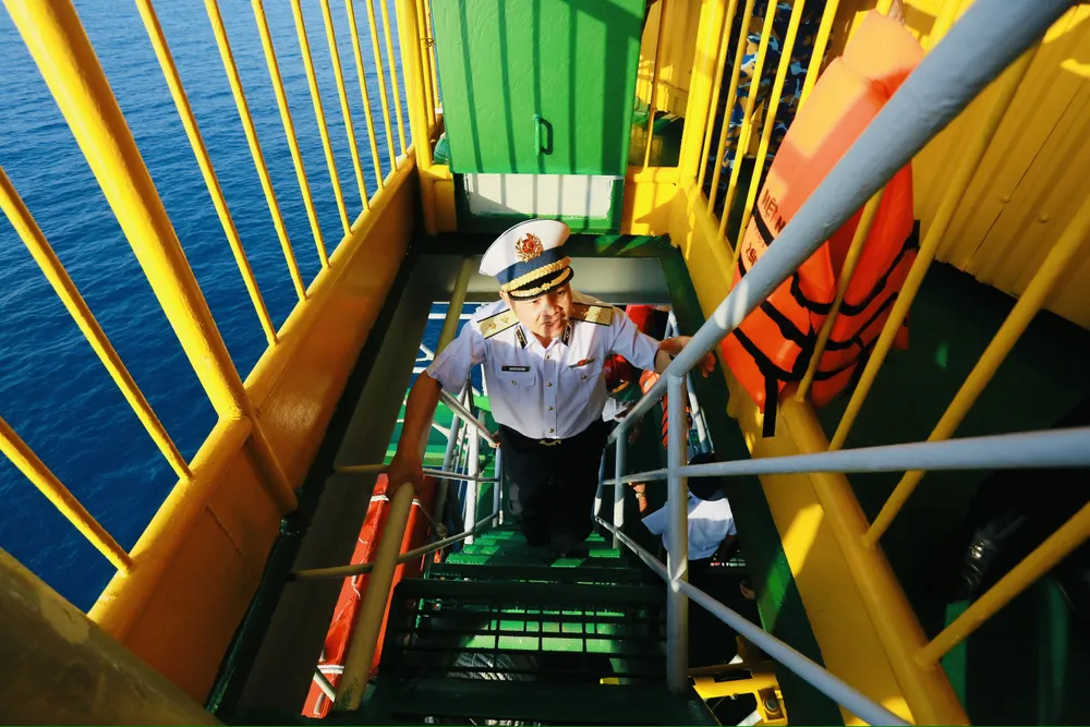 Trung tướng Nguyễn Văn Bổng, Chính ủy quân chủng Hải quân di chuyển bằng lối cầu thang sắt để lên thăm cán bộ, chiến sĩ Nhà giàn DK1/10. Ảnh: CHÍ THẠCH