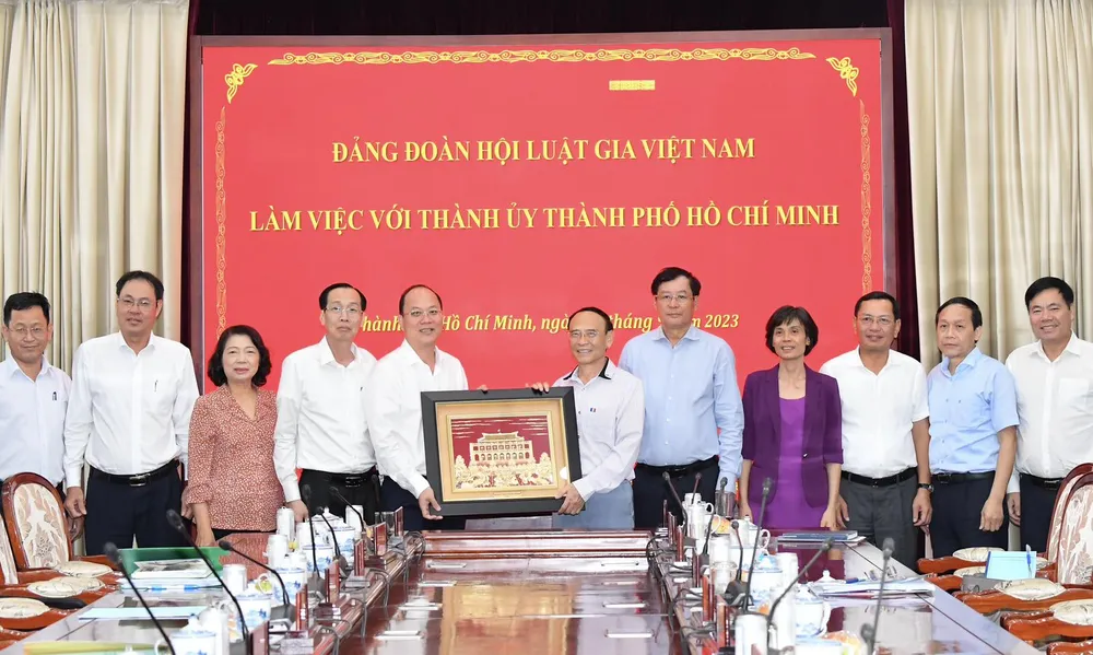 Lãnh đạo TPHCM tặng quà lưu niệm cho đoàn công tác Đảng đoàn Hội Luật gia Việt Nam. Ảnh: VIỆT DŨNG