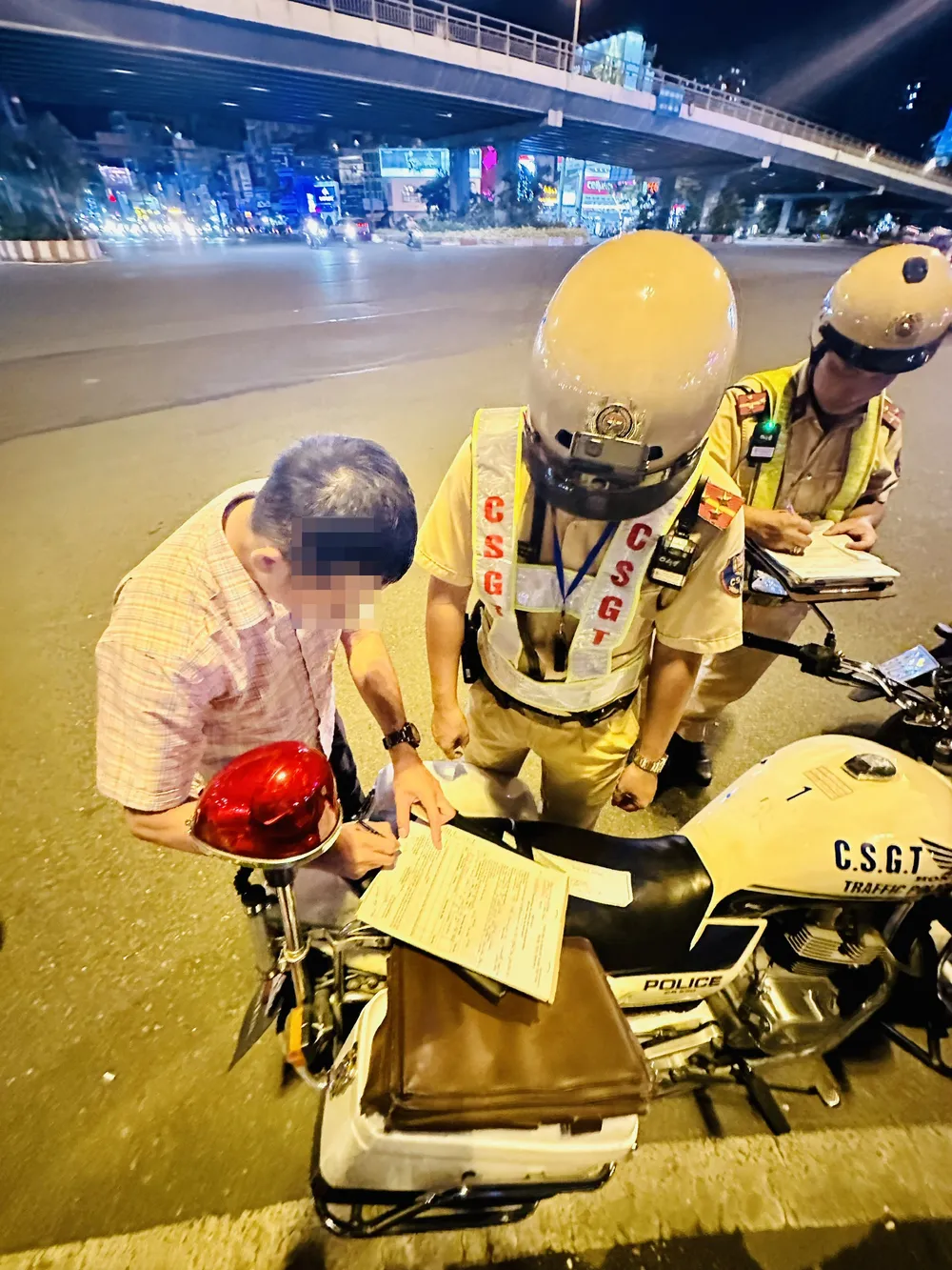 Ông N. ký vào biên bản vi phạm. Ảnh: CHÍ THẠCH