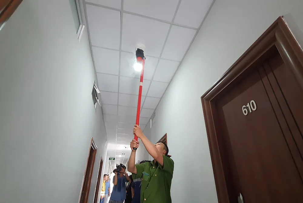 Công an dùng nguồn nhiệt kiểm tra hệ thống báo cháy tại khu vực hành lang nhà trọ
