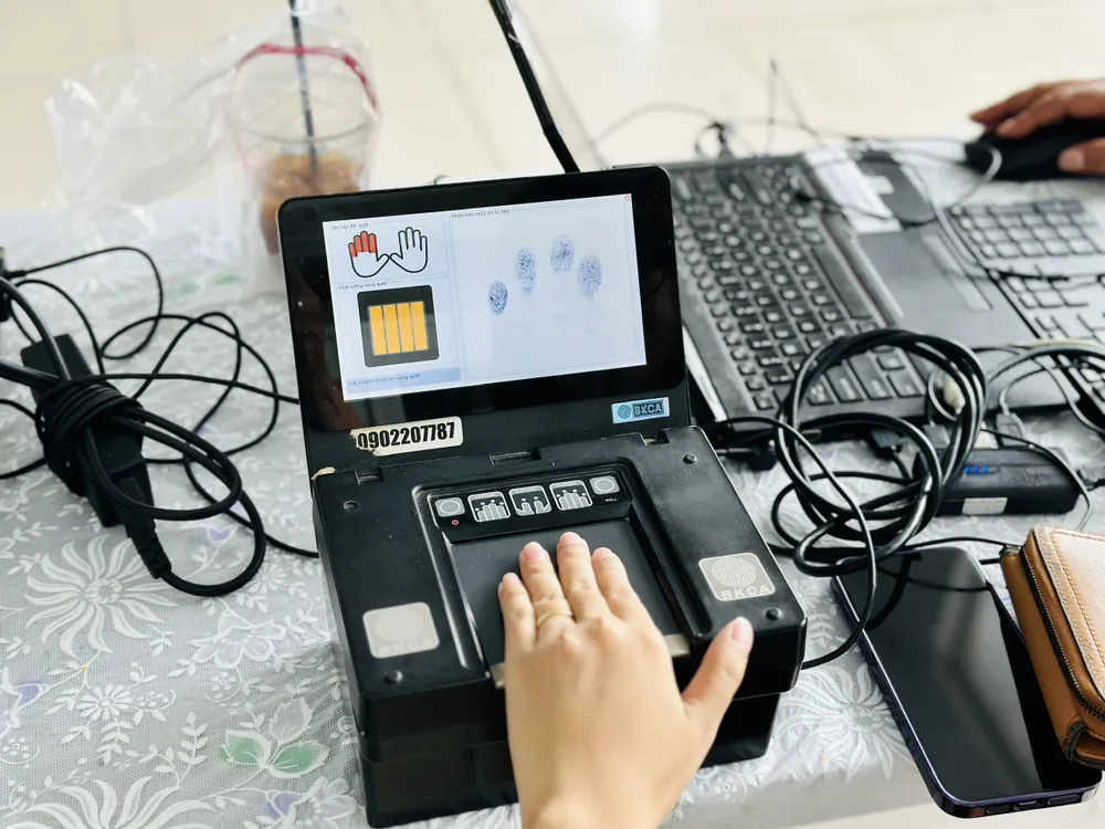 Người dân được lăn tay để cấp tài khoản định danh điện tử mức 2. Ảnh: CHÍ THẠCH