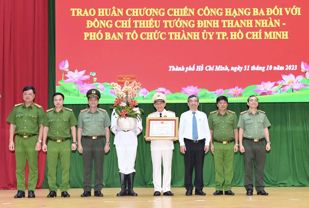 Phó Bí thư Thành ủy Nguyễn Phước Lộc cùng Ban Giám đốc Công an TPHCM chúc mừng đồng chí Đinh Thanh Nhàn. Ảnh: VIỆT DŨNG