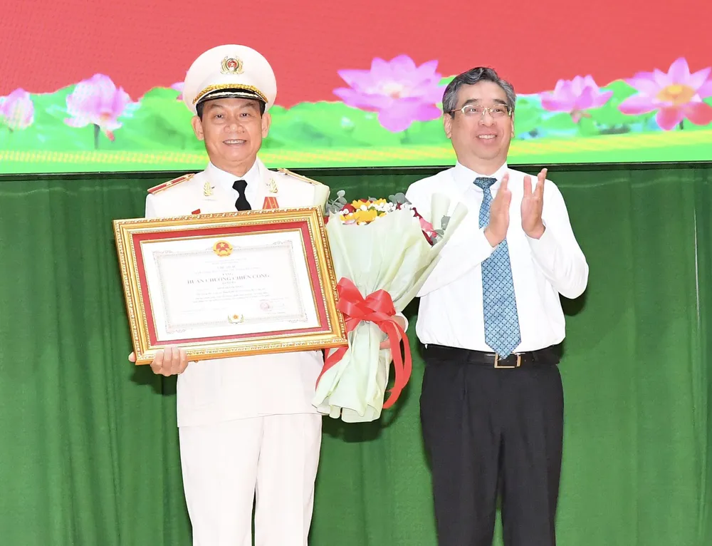 Phó Bí thư Thành ủy TPHCM Nguyễn Phước Lộc trao Huân chương Chiến công hạng Ba cho Thiếu tướng Đinh Thanh Nhàn. Ảnh: VIỆT DŨNG