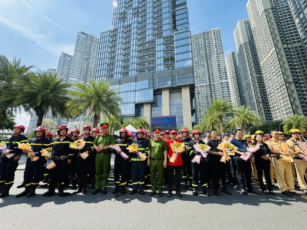 Thượng tá Nguyễn Đình Dương, Phó Giám đốc Công an TPHCM cùng lãnh đạo các đơn vị tặng hoa chúc mừng các lực lượng chức năng tham gia diễn tập chữa cháy ở tòa nhà Landmark 81, Khu đô thị Vinhomes Central Park. Ảnh: CHÍ THẠCH