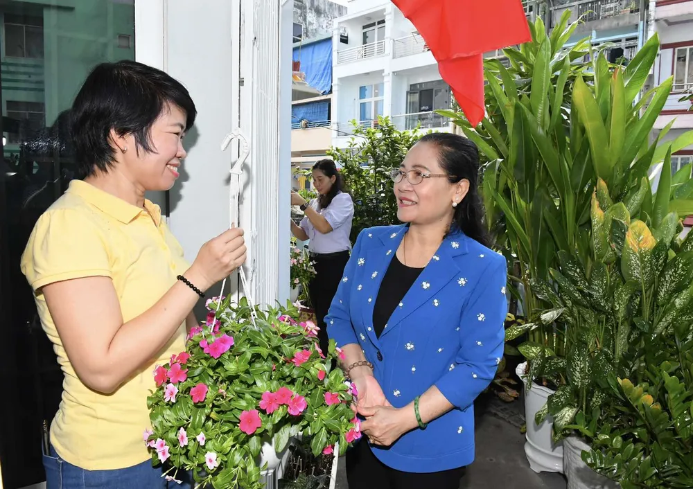 Chủ tịch HĐND TPHCM Nguyễn Thị Lệ tặng hoa cho các hộ dân. Ảnh: VIỆT DŨNG