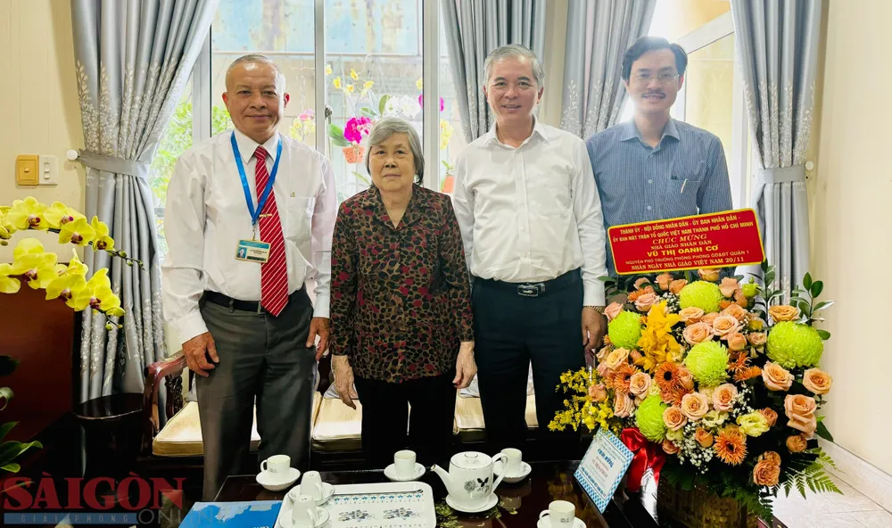 Phó Chủ tịch UBND TPHCM Ngô Minh Châu tặng hoa chúc mừng Nhà giáo nhân dân Vũ Thị Oanh Cơ. Ảnh: CHÍ THẠCH