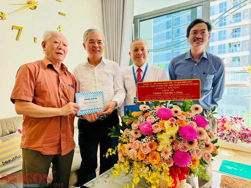 Phó Chủ tịch UBND TPHCM Ngô Minh Châu tặng hoa chúc mừng TS Trần Thành Long. Ảnh: CHÍ THẠCH