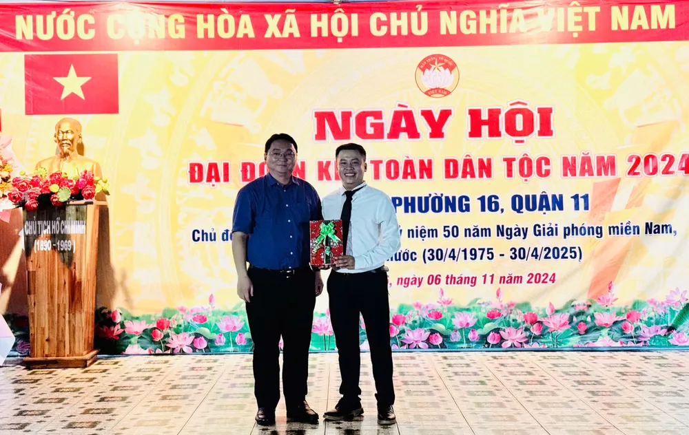 Lãnh đạo quận 11 tặng hoa chúc mừng Ban Công tác Mặt trận khu phố 3 (phường 16, quận 11). Ảnh: CHÍ THẠCH