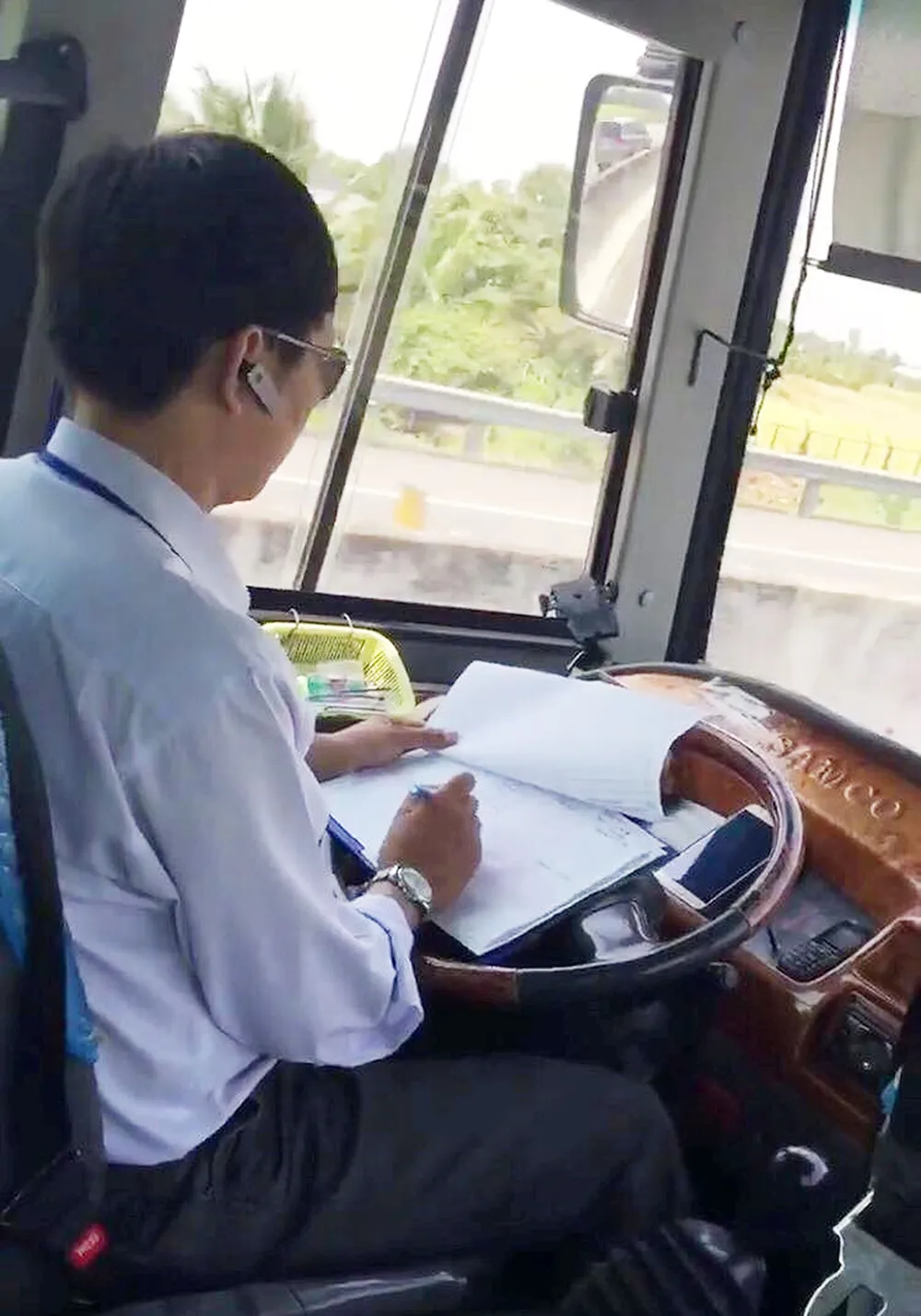 Ủy ban ATGT Quốc gia yêu cầu xử lý tài xế vừa lái xe vừa xử lý giấy tờ ảnh 1