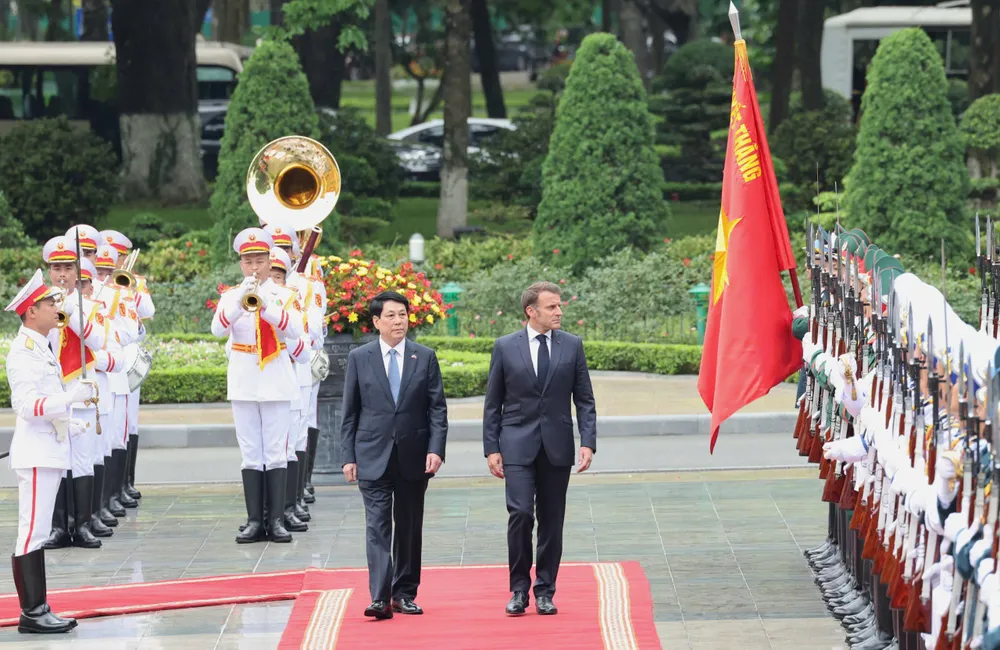 Chủ tịch nước Lương Cường và Tổng thống Pháp Emmanuel Macron duyệt đội danh dự Quân đội nhân dân Việt Nam tại lễ đón chính thức, sáng 26-5. Ảnh: QUANG PHÚC
