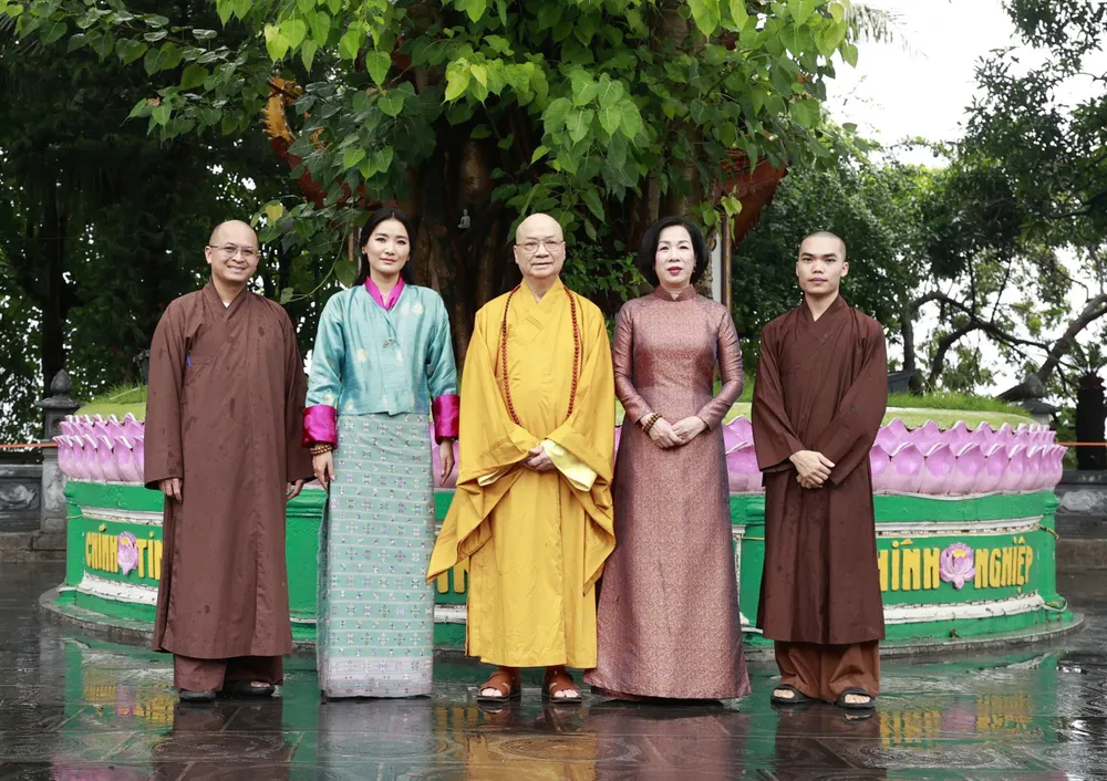Phu nhân Nguyễn Thị Minh Nguyệt và Hoàng hậu Jetsun Pema Wangchuck chụp ảnh cùng Hòa thượng Thích Thanh Nhã tại cây bồ đề, sáng 19-8. Ảnh: VIẾT CHUNG