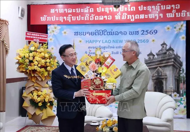 Phó Bí thư Thành ủy TPHCM Đặng Minh Thông tặng quà chúc Tết Tổng lãnh sự Lào tại TPHCM Phonesy Bounmixay, nhân dịp Tết cổ truyền của Lào. Ảnh: TTXVN