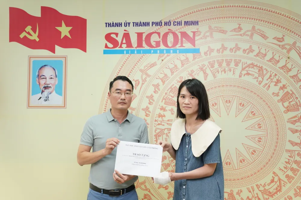 Đại diện Báo SGGP tại Hà Nội trao số tiền 18 triệu đồng đến chị Bùi Thị Phương