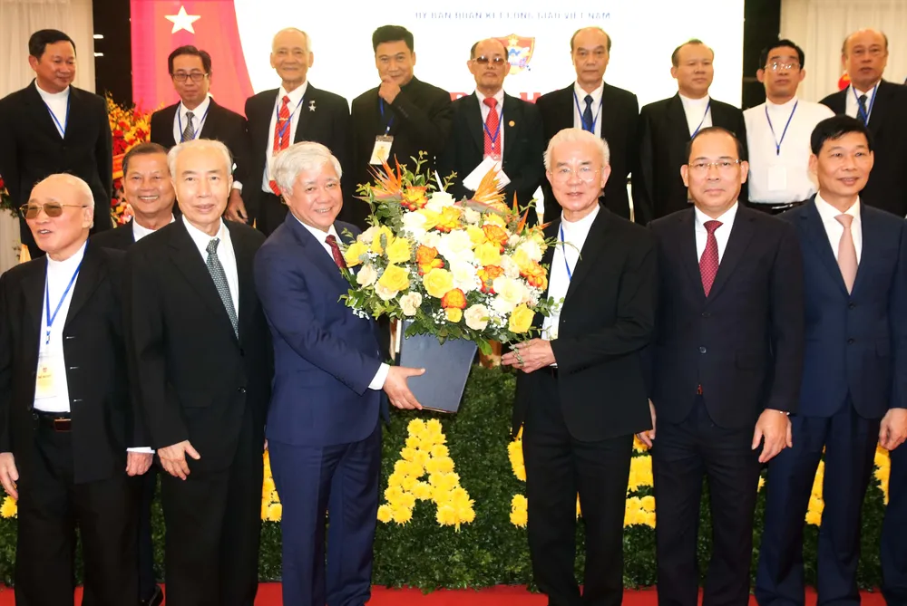 Chủ tịch Ủy ban Trung ương MTTQ Việt Nam Đỗ Văn Chiến (trái) tặng hoa chúc mừng Linh mục Giuse Trần Xuân Mạnh. Ảnh: TIẾN ĐẠT