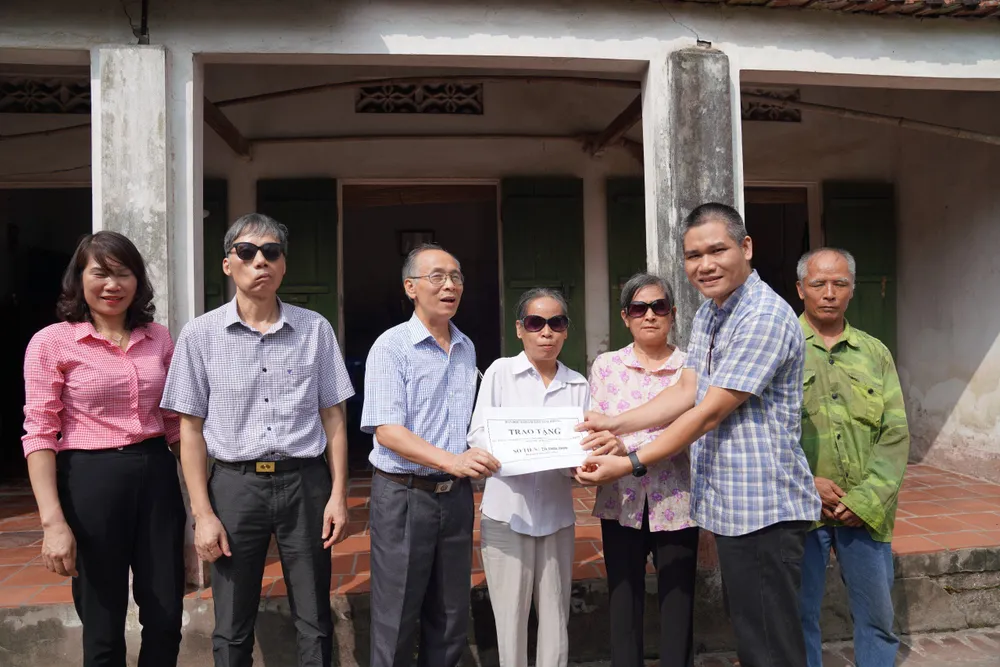 Đại diện Báo SGGP trao tiền bạn đọc đến gia đình bà Đỗ Thị Luyện và Đỗ Thị Út