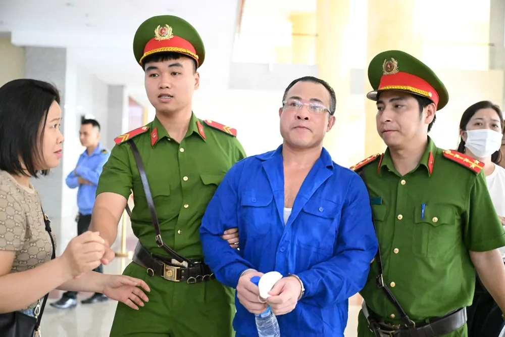 Bị cáo Nghiêm Quang Minh được dẫn giải vào phòng xử. Ảnh: ĐỖ TRUNG