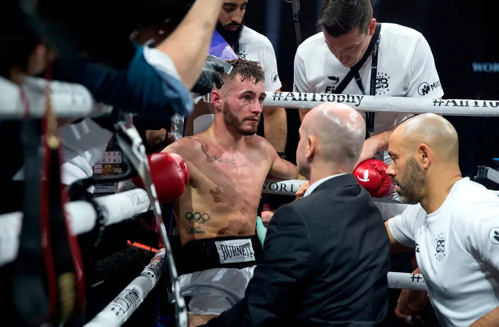 Quyền Anh: Dính chấn thương kỳ lạ, Burnett mất đai WBA, phải rời sàn trên cáng ảnh 1