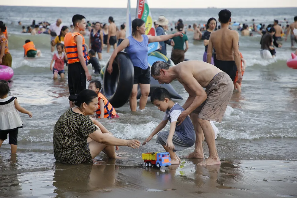Ông bà và cháu cùng chơi trên biển