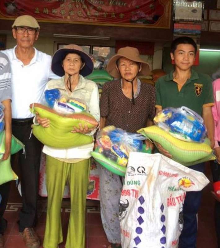 越僑姚保昌(左一)向貧戶贈送禮物。 