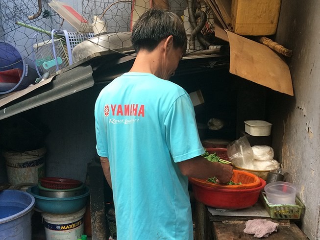 雄叔在狹窄的小屋裡準備飯菜。