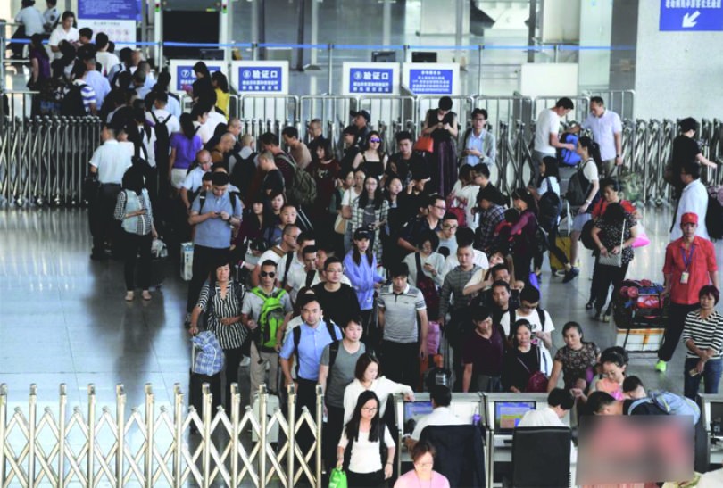 民眾在排隊檢票進站候車。