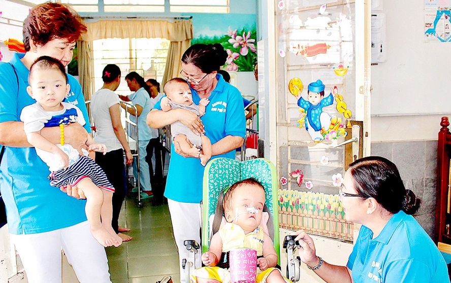 第十街區婦女分會在氏藝殘疾-孤兒收養中心照顧病童。