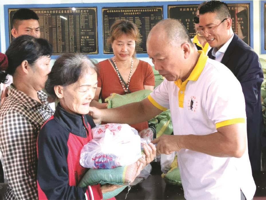 鄭成龍理事長向窮人派發禮物。