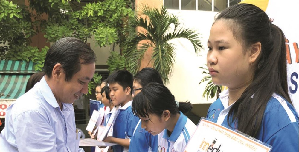 李鋒中學校長陳晉才向優秀生頒發獎學金。