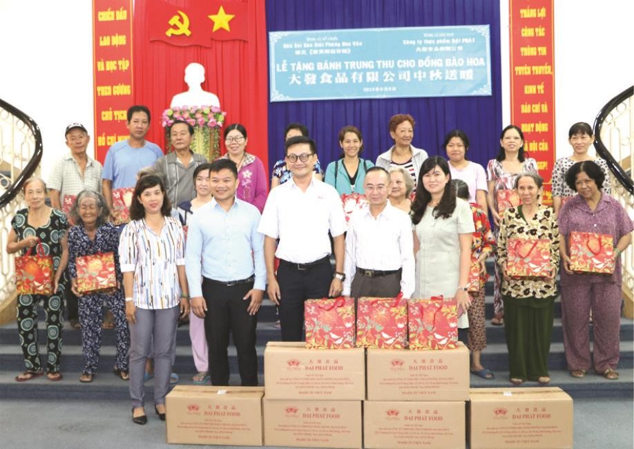 黃副總經理與本報領導向華人贈送月餅。