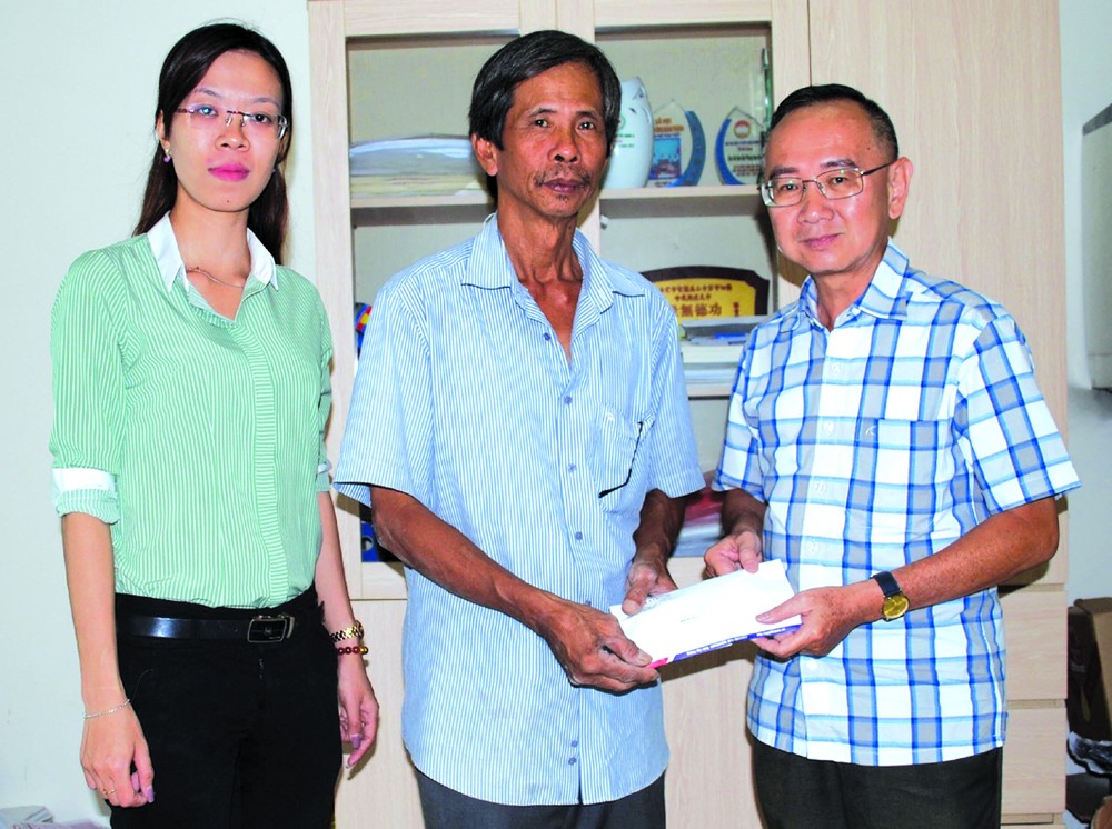 本報編委兼編輯部主任范興（右一）向畢業祥轉交5000萬元建溫情屋經費。