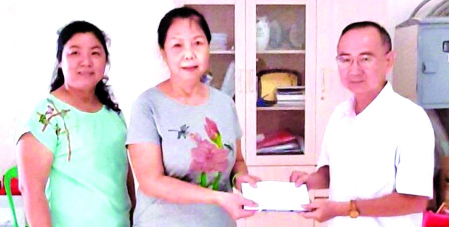 本報編委兼編輯部主任范興(右一)向林秀蓉移交4000萬元修繕房屋經費。